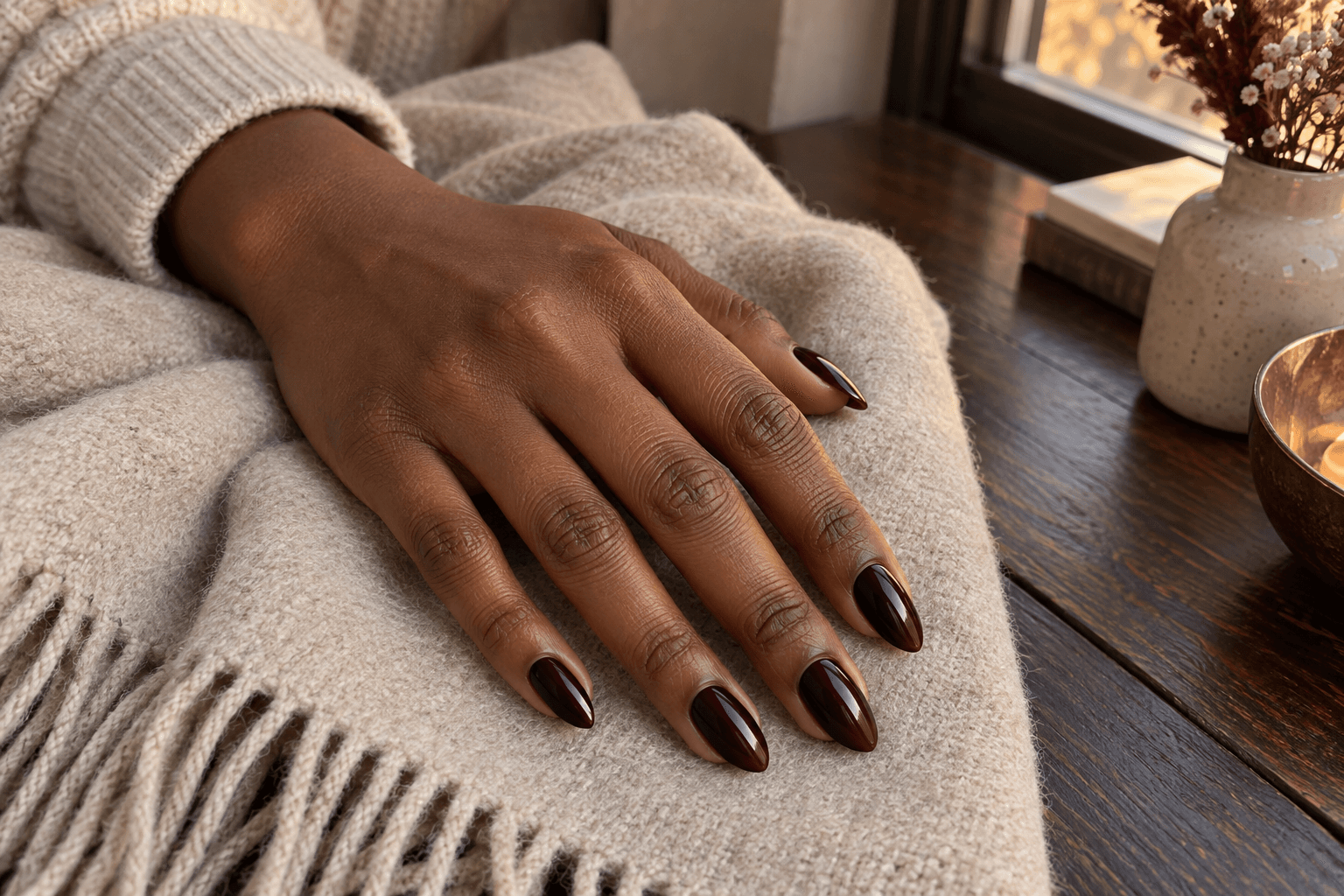Deep black-cherry almond nails with wine-red highlights against an oatmeal scarf.