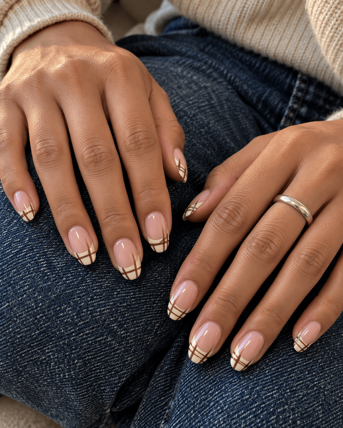 Pink-beige base; cream French tips containing a sparse brown plaid; no lines extending below the tip boundary