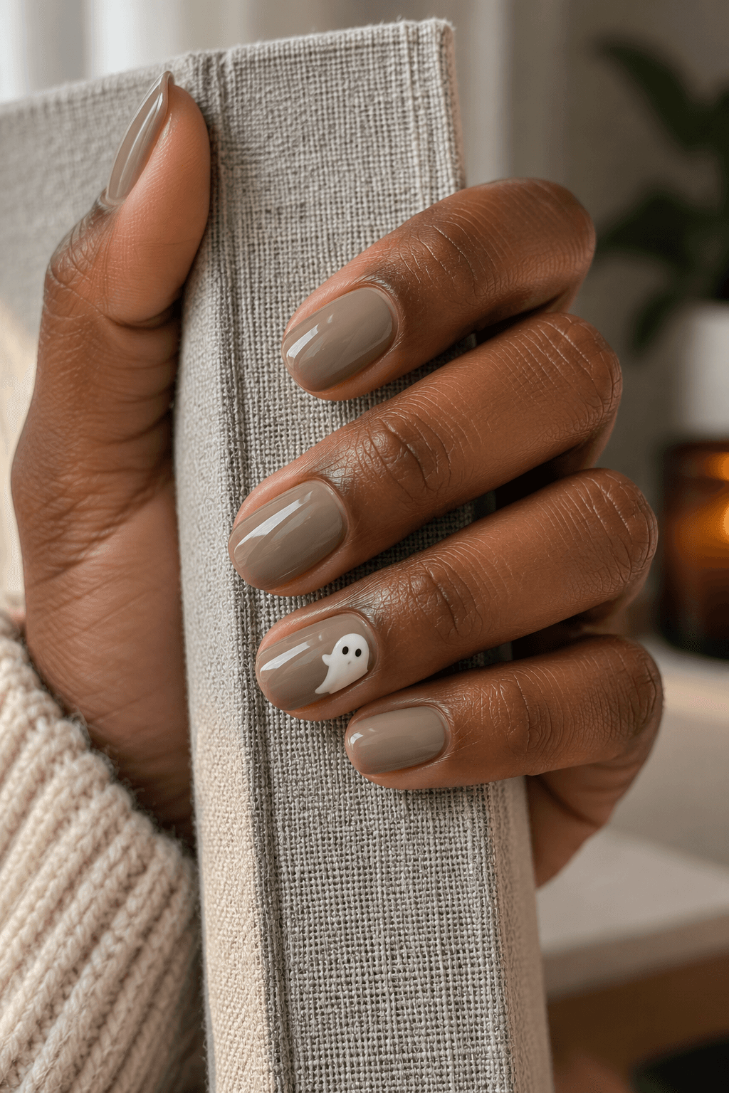 Short taupe nails with part of a small cream ghost visible at one side of an accent nail.